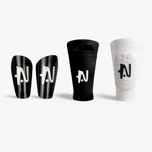 Product photo of NTMG black classic shin guards, the black NTMG original sleeve and white built-in shin pads against a white background.
