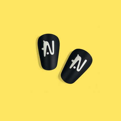 Two black shin guards with a logo on a yellow background