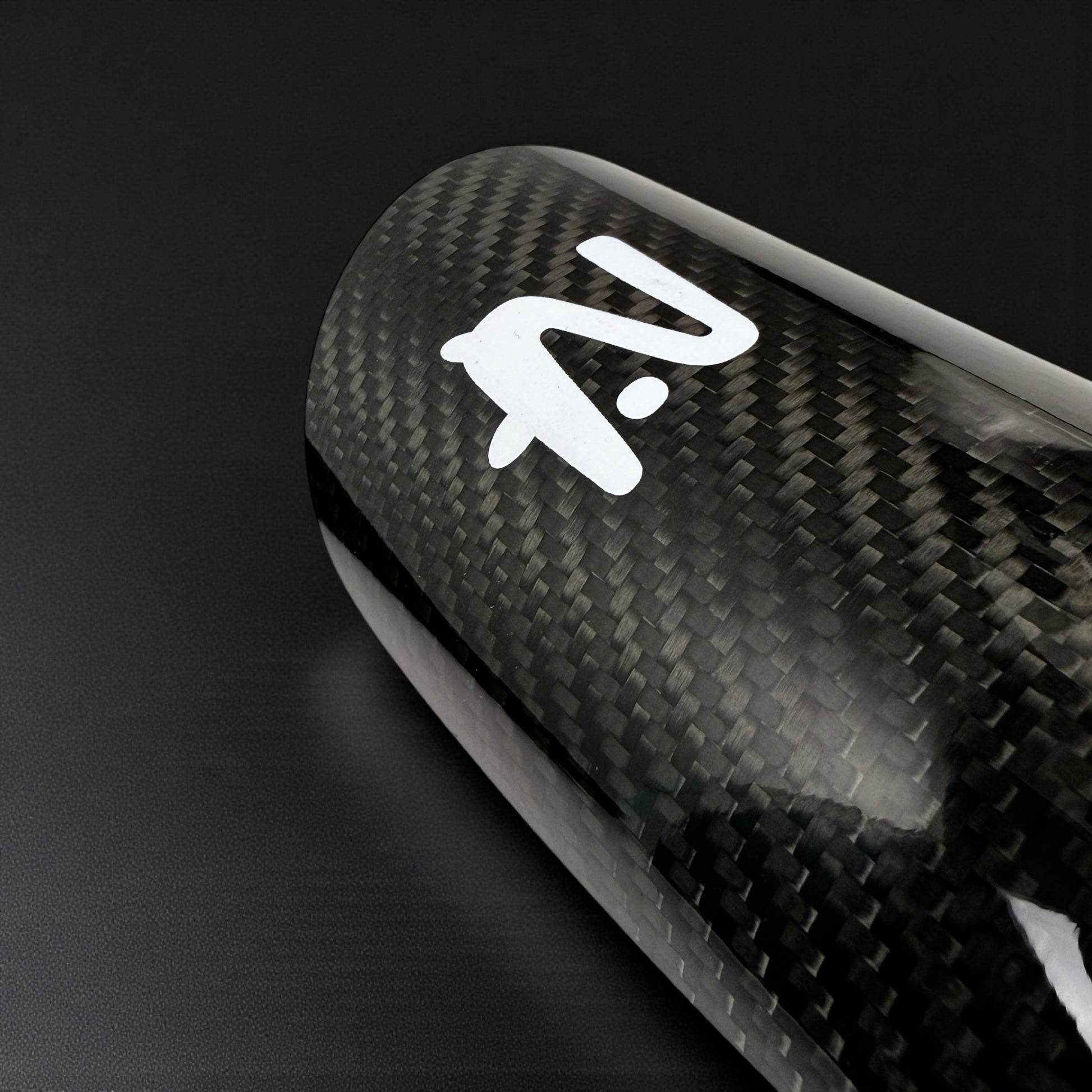 Carbon fiber surface with a white logo on a black background