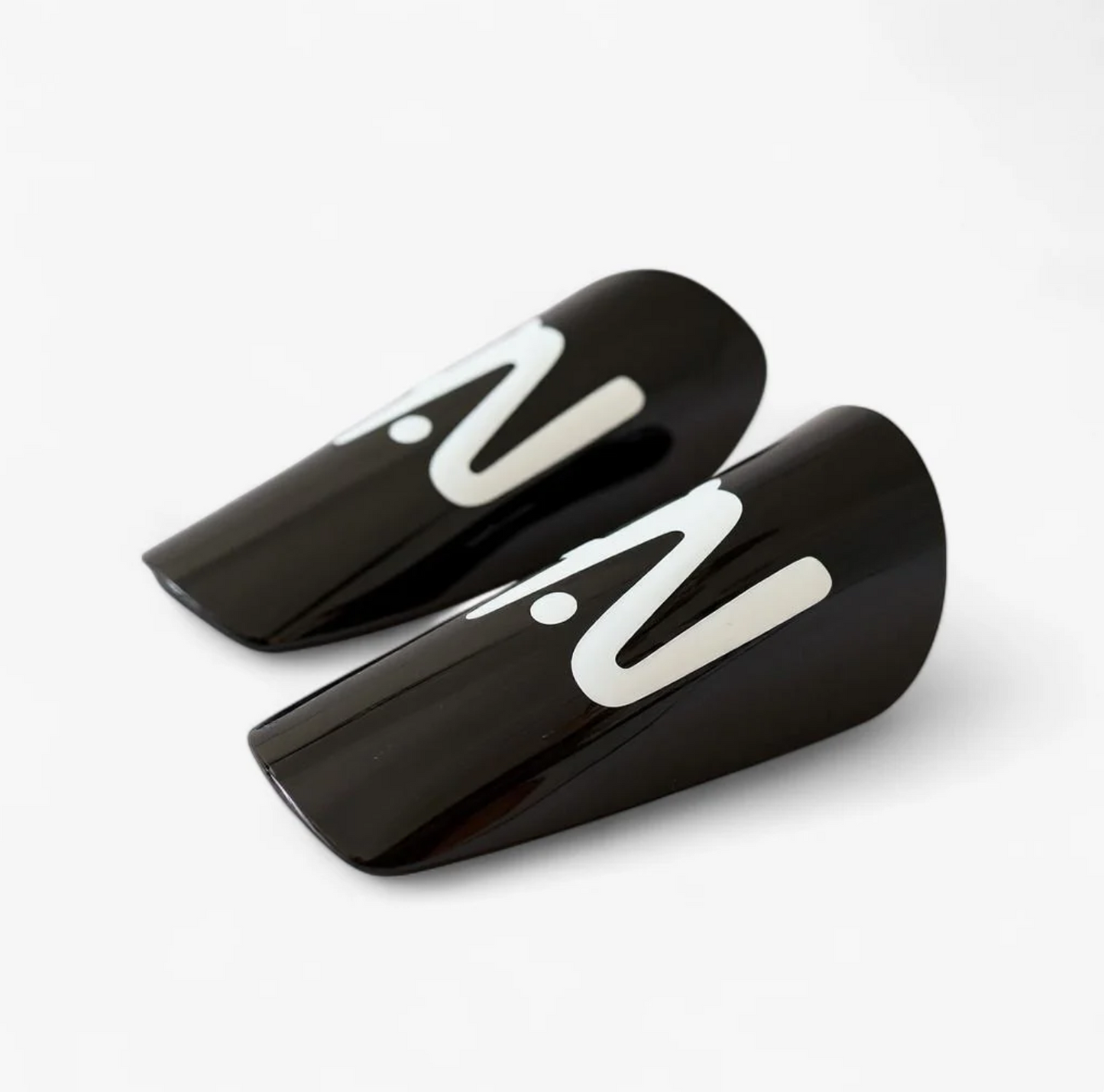 Two black shin guards with white 'N' logo on a white background