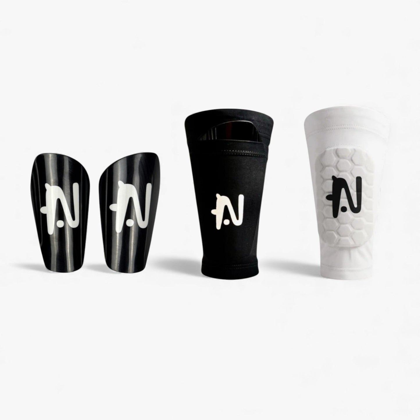 Product photo of NTMG black classic shin guards,  the black NTMG original sleeve and white built-in shin pads against a white background.