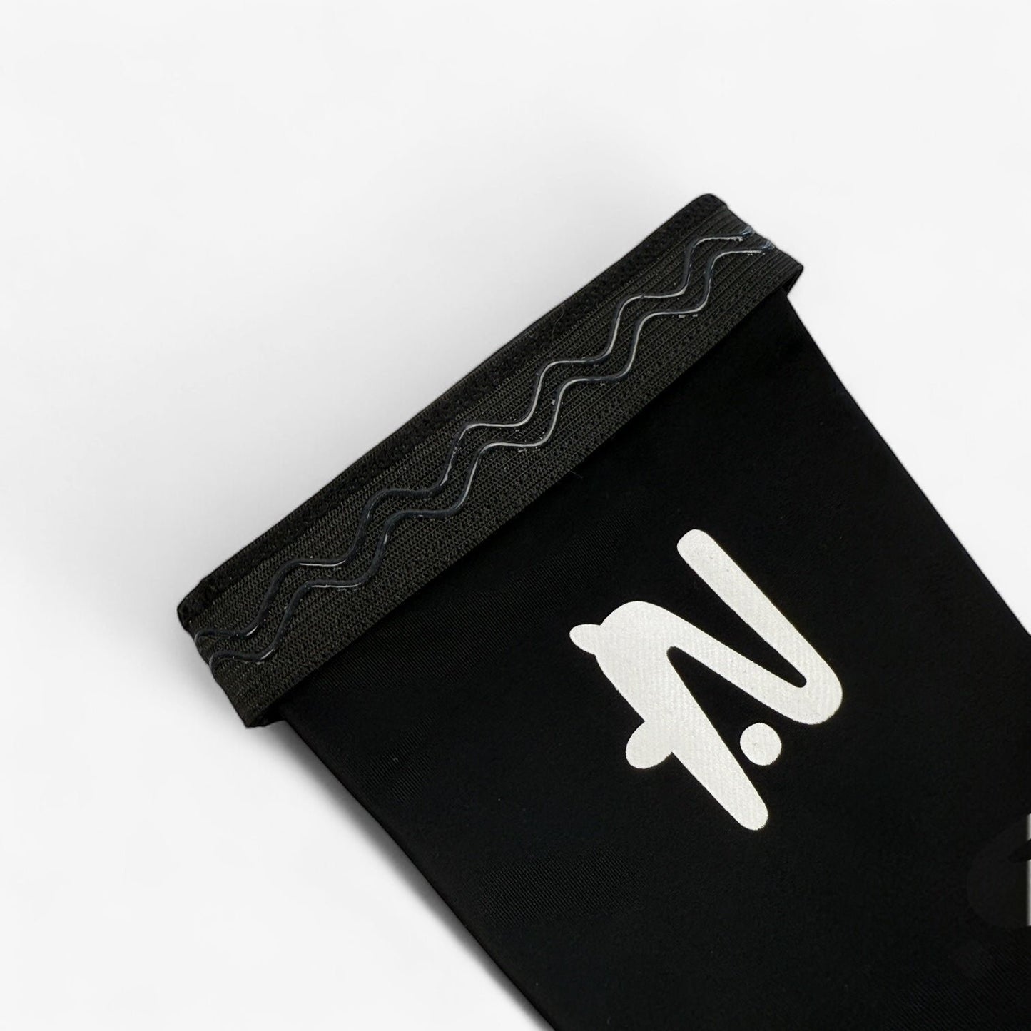 Black sleeve with a white logo on a light grey background. The silicone lip that holds the sleeve in place is showing.