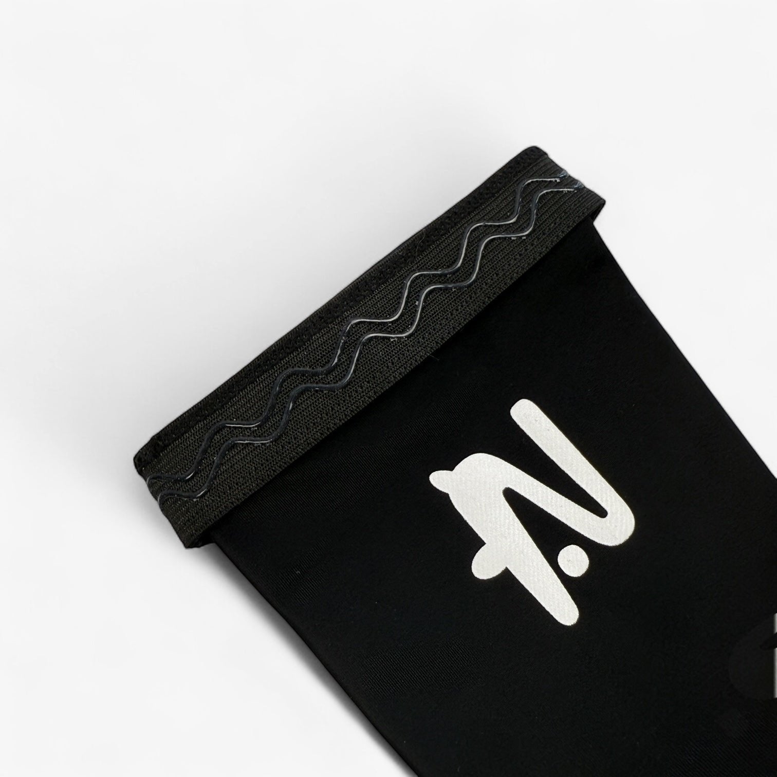 Black sleeve with a white logo on a light grey background. The silicone lip that holds the sleeve in place is showing.