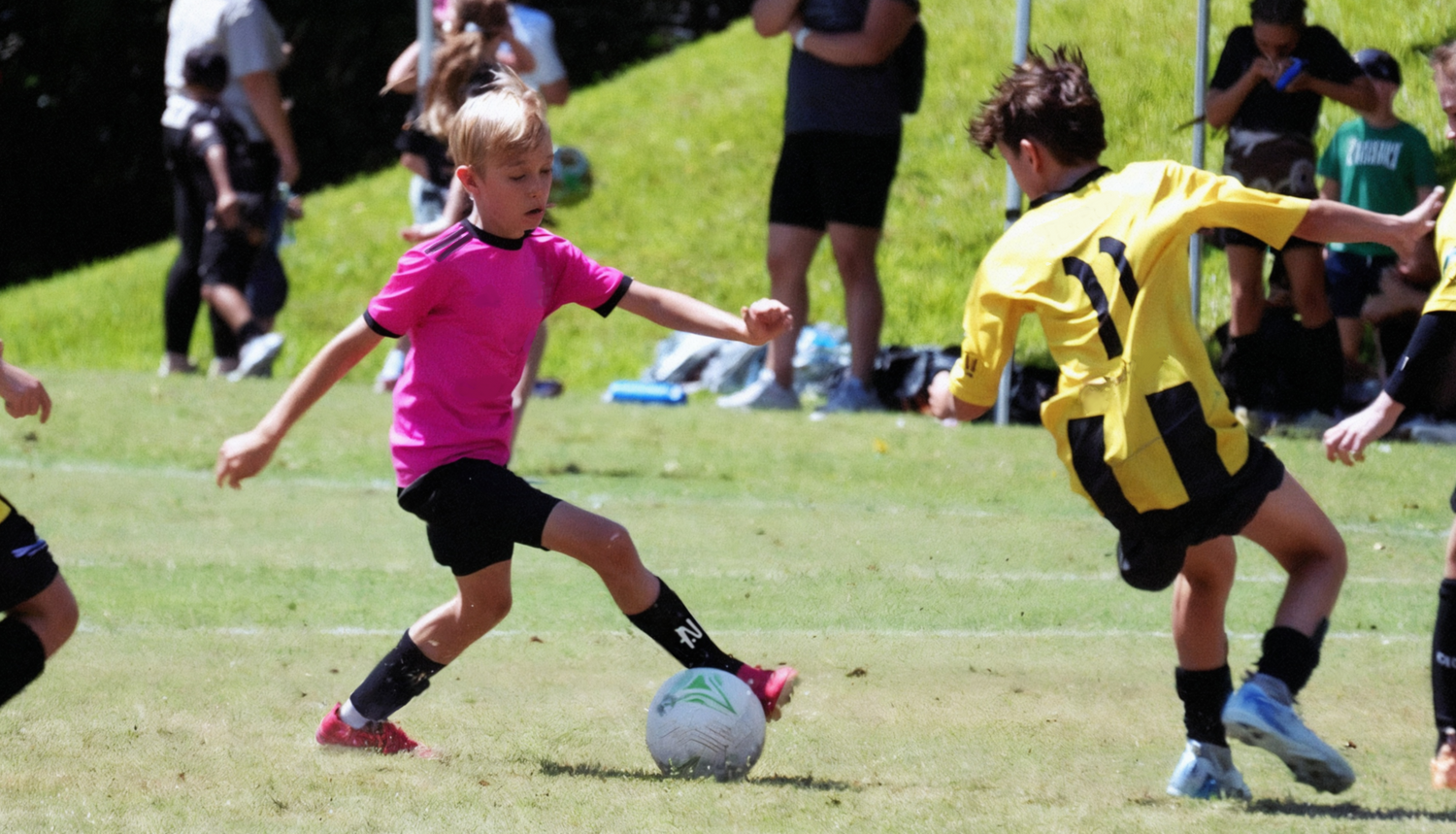 A young footballer wearing black NTMG sleeved shin pads, side steps 3 players wearing traditional bulky shin pads who can't keep up.